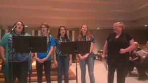 Lori True (right) sings with All Saints choir members